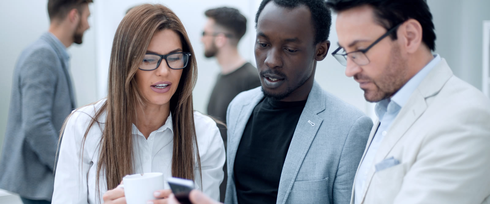 Three Work Colleagues Looking at a Phone